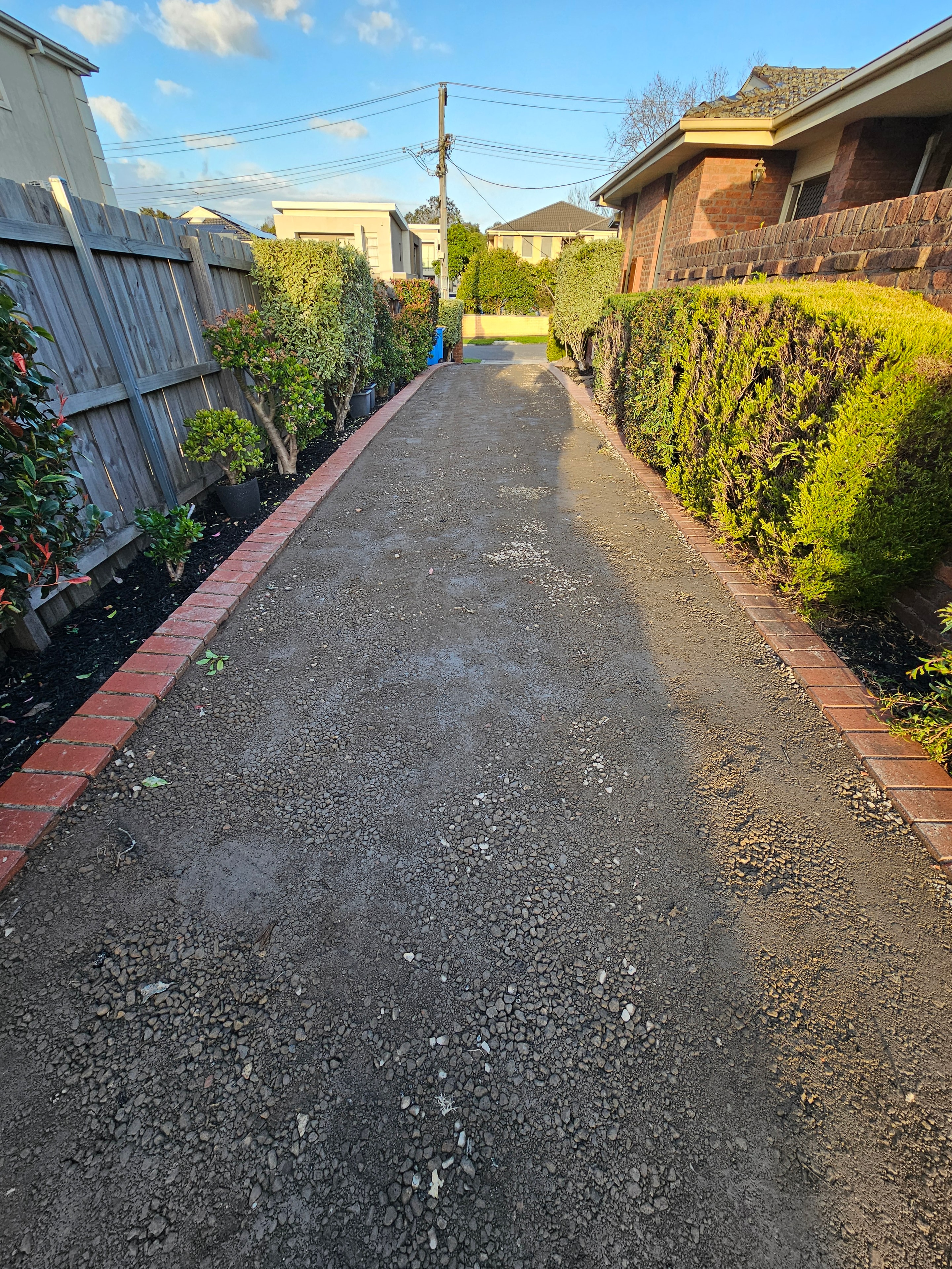 Residential driveway asphalt laying with brick edging